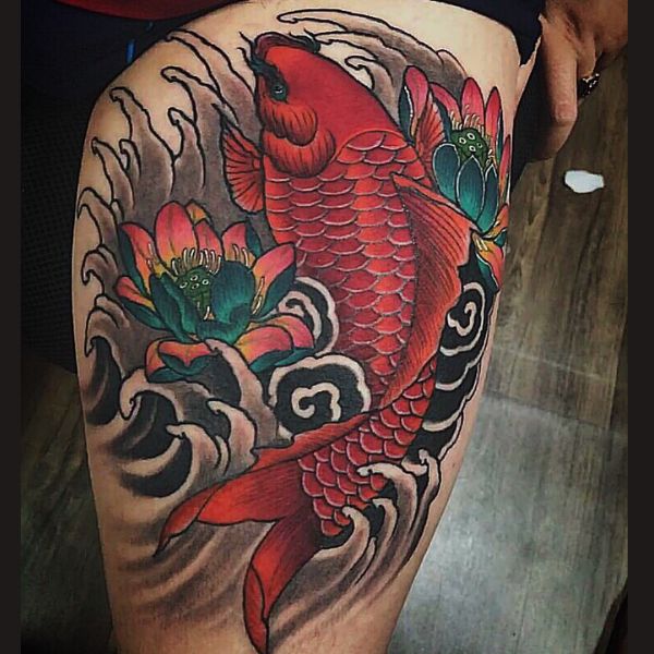 a tattoo of a fish and flowers