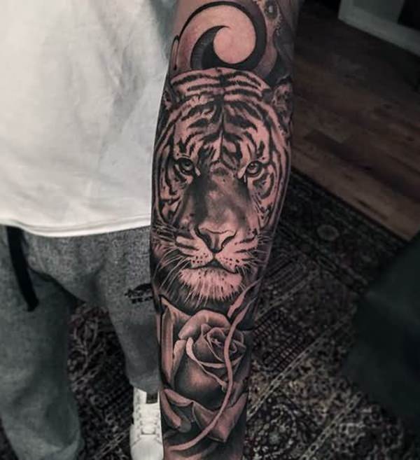 a person's arm with a tattoo of a tiger and a rose